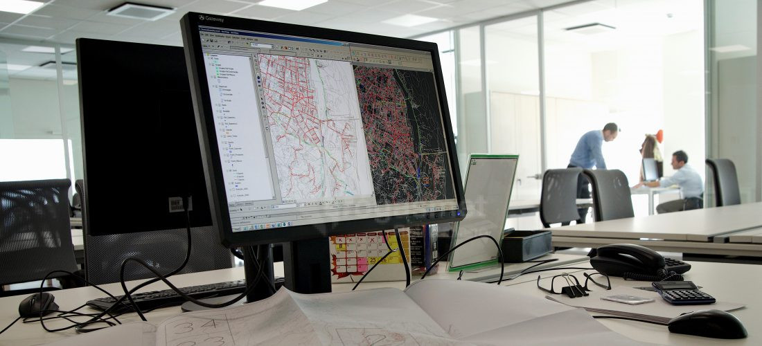 Vista dell'interno di un ufficio con lo schermo di un computer acceso su una cartografia